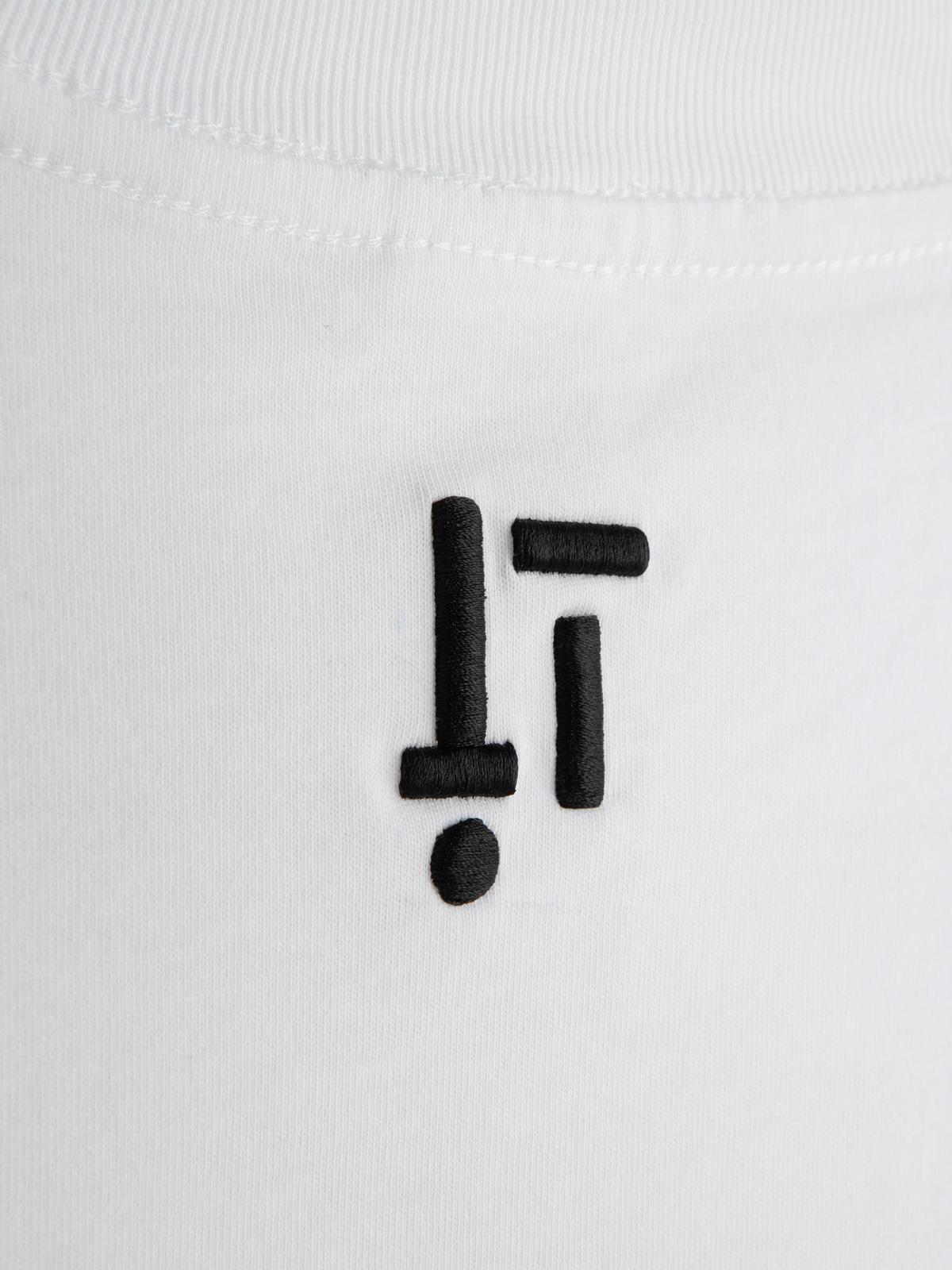 Black exclamation mark and dot embroidery on a white fabric background